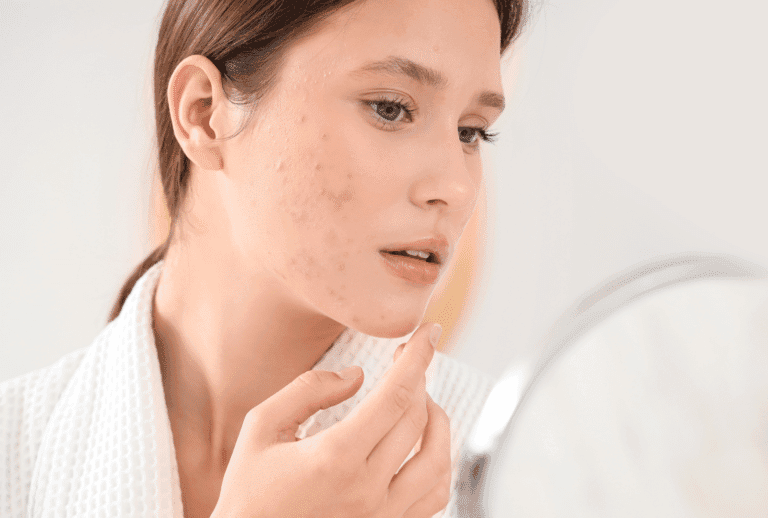 Femme examinant sa peau dans un miroir