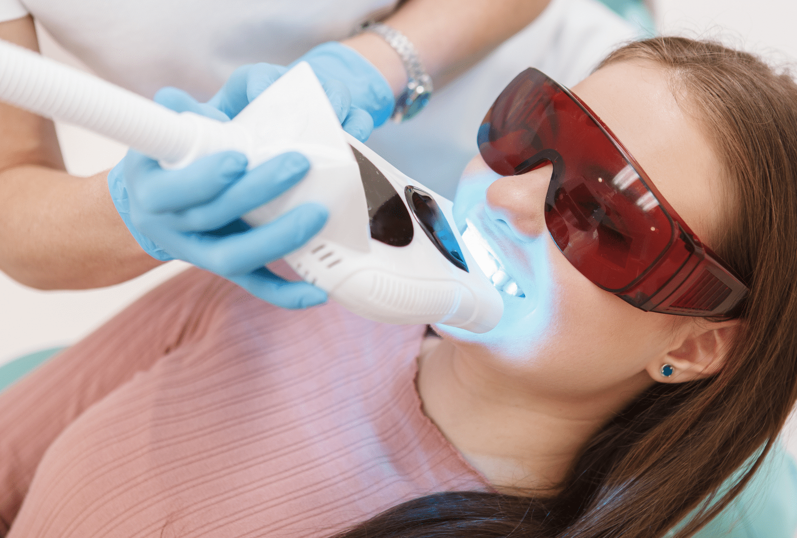 Patiente recevant un blanchiment dentaire professionnel avec lampe à lumière.