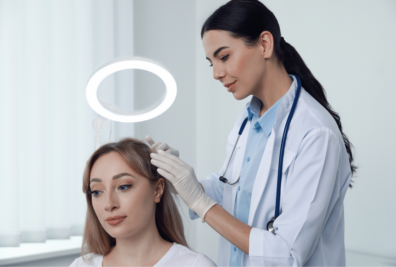 Médecin examinant le cuir chevelu d’une patiente lors d’une consultation capillaire.
