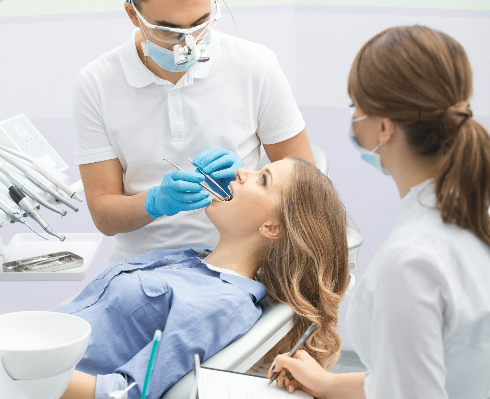 Patiente lors d’une consultation dentaire avec un dentiste et son assistante en clinique.