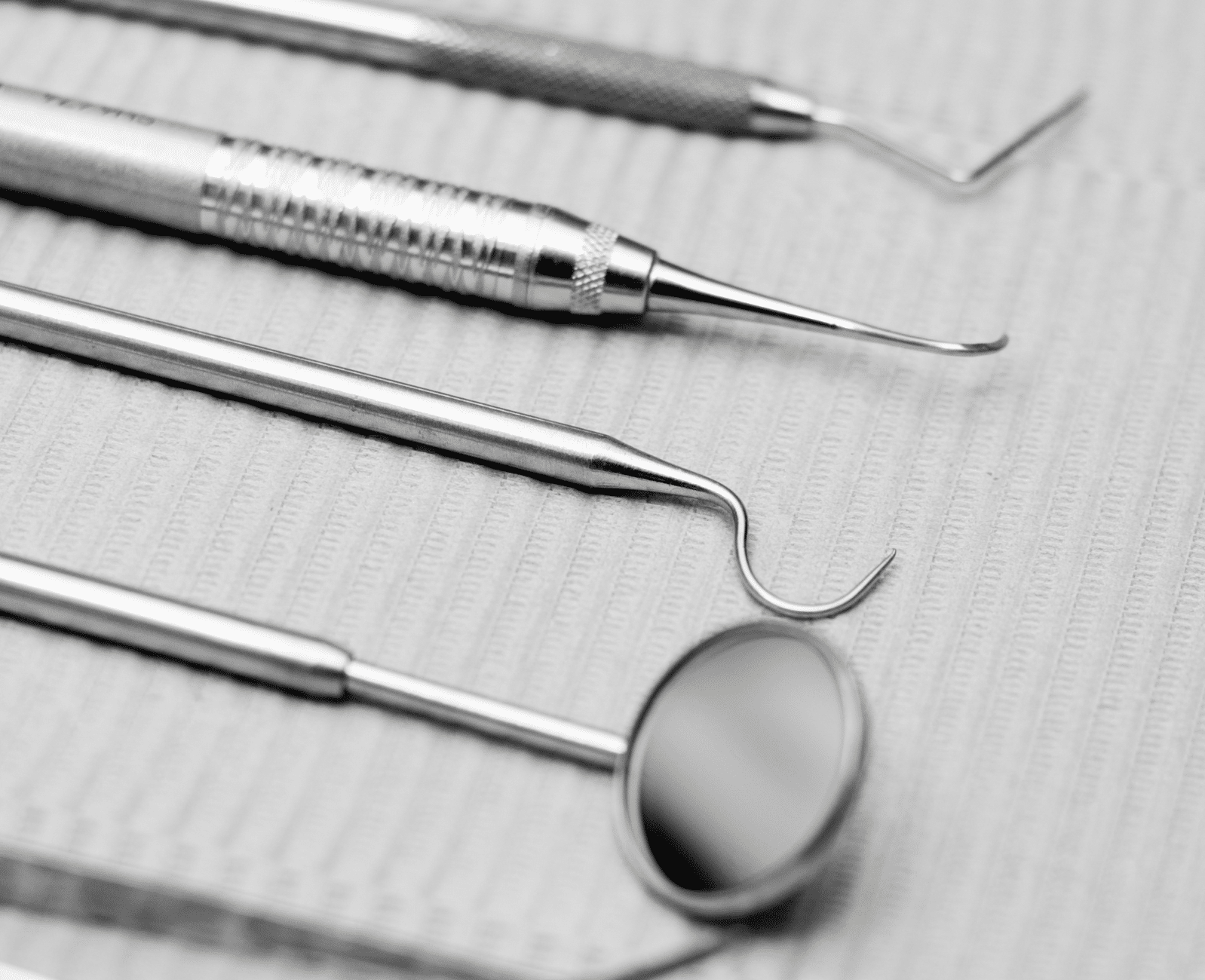 Ensemble d’instruments dentaires en acier utilisés pour les soins et examens bucco-dentaires.