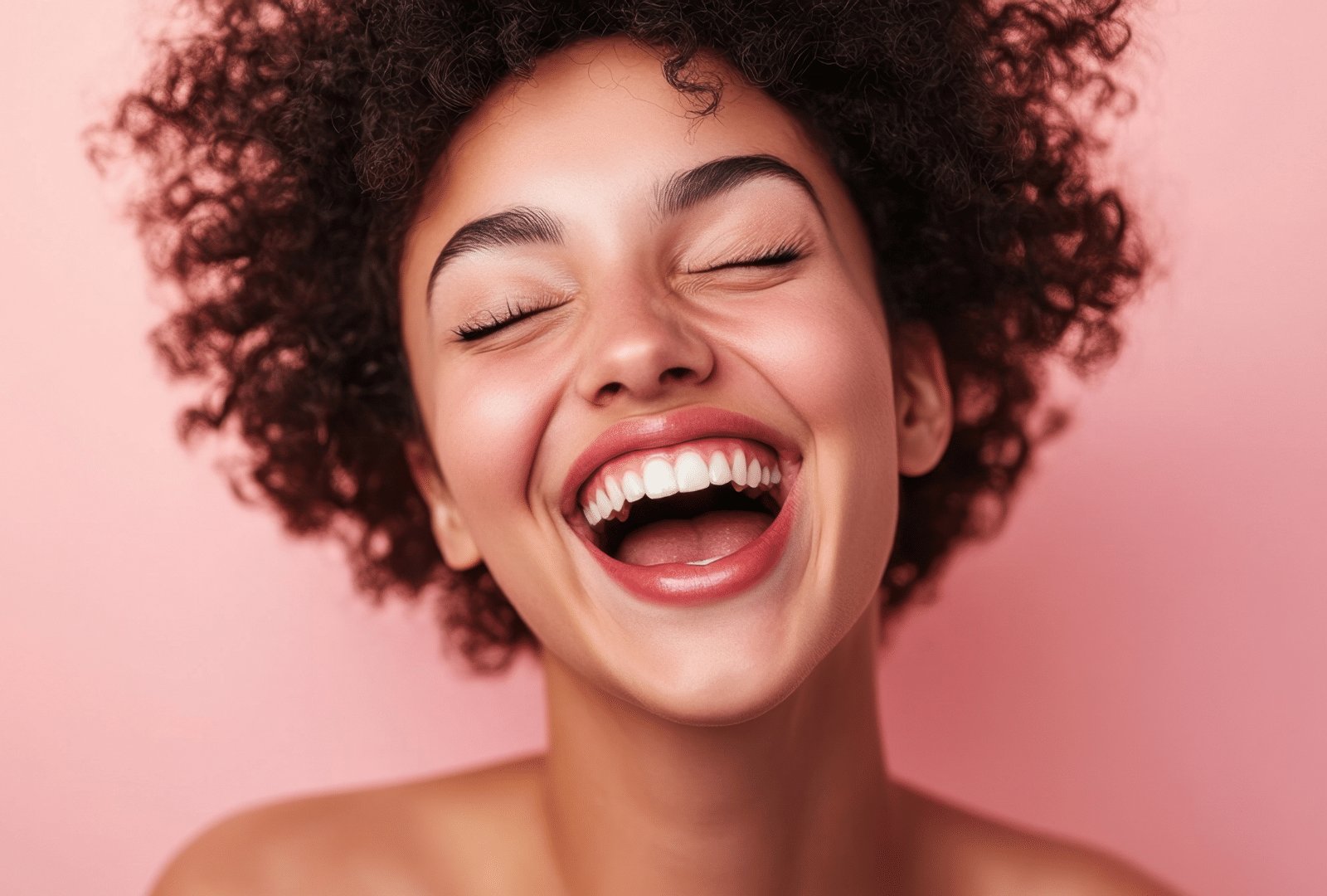 Femme souriante avec cheveux bouclés sur fond rose