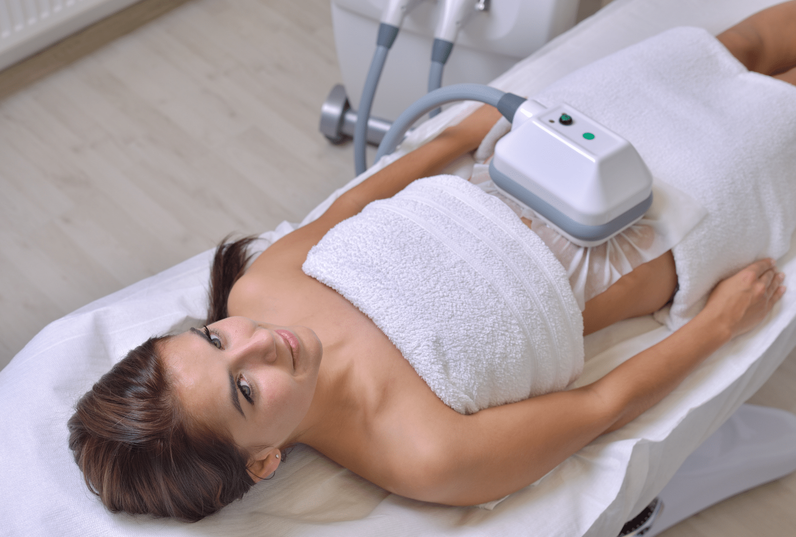 Femme en soin minceur sur une table de traitement.