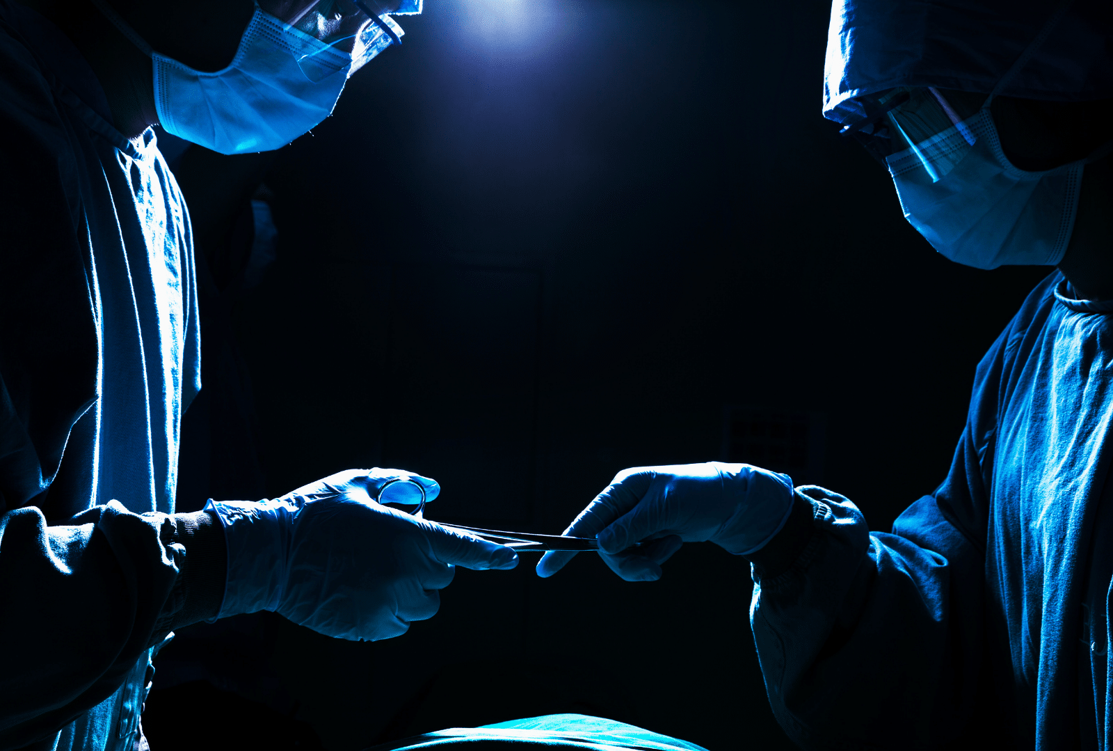 Personnel médical échangeant des instruments chirurgicaux à l'hôpital.