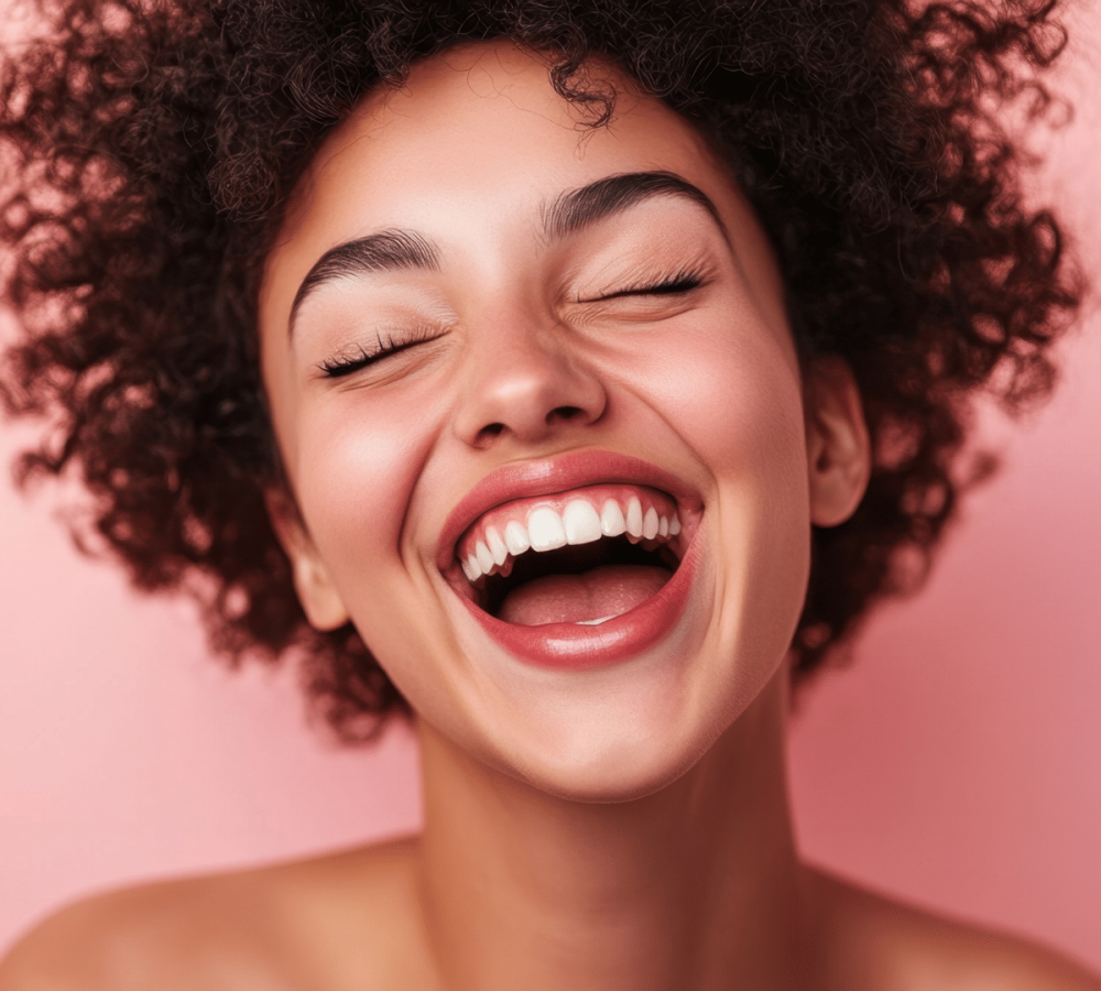 Femme souriante avec cheveux bouclés sur fond rose