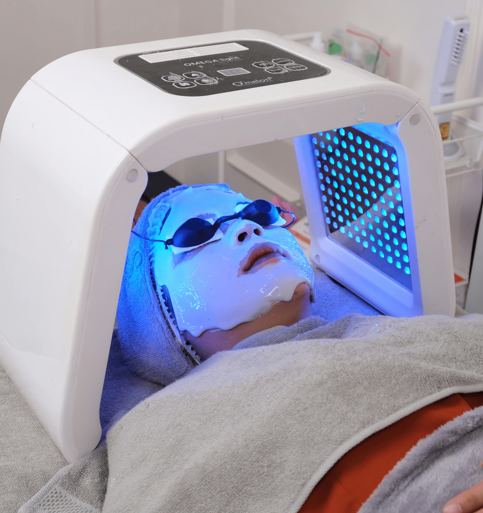 Soin facial avec lumière bleue et masque hydratant.