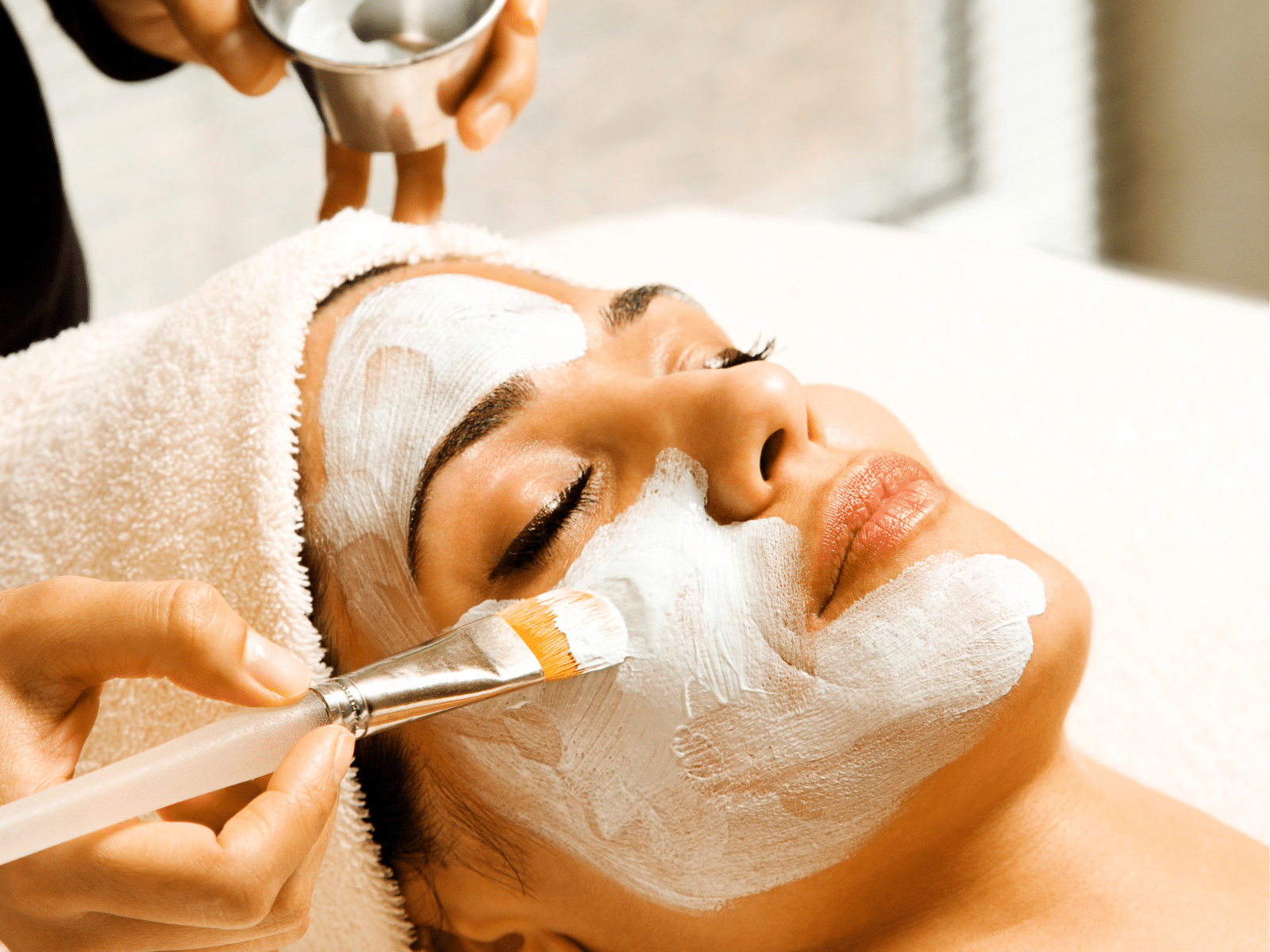 Application de masque facial relaxant sur une cliente.