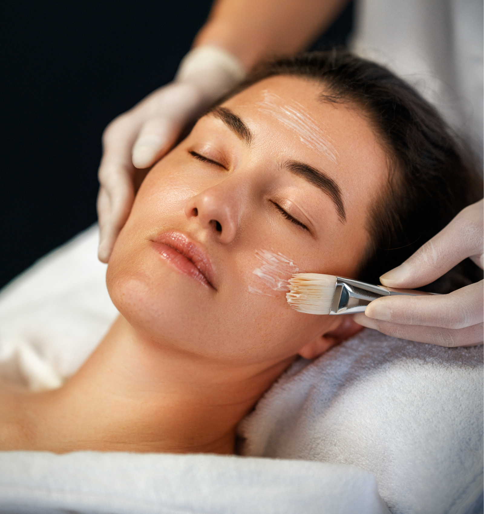 Application d’un soin dermatologique esthétique sur le visage d’une femme.